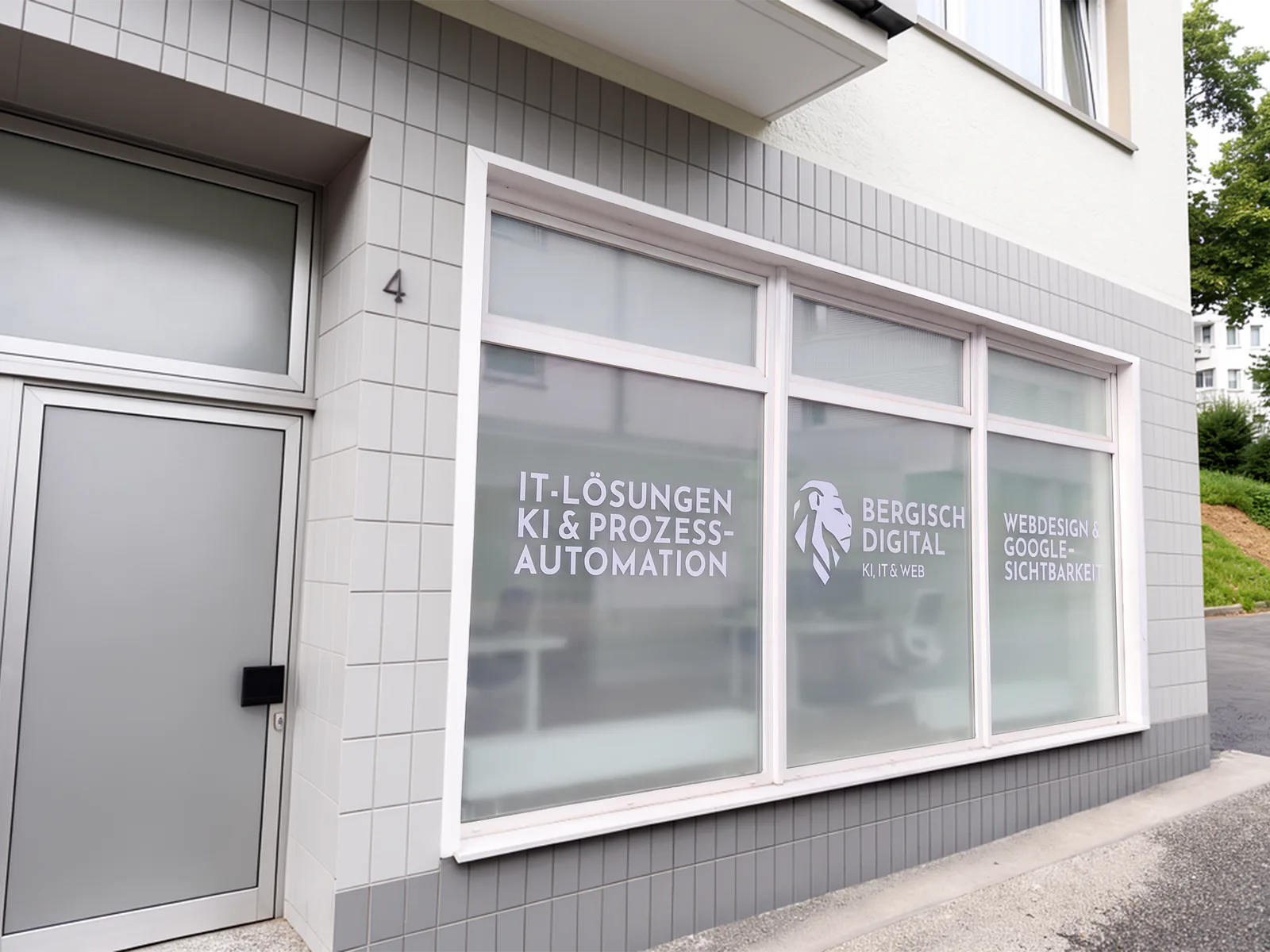 Das Büro von Bergisch Digital in der Kremenhollerstraße 4 in Remscheid: ein Schaufenster mit der Beschriftung „IT-Lösungen, KI und Prozessautomation“, dem Logo und „Webdesign und Google-Sichtbarkeit“.